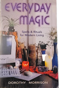 The front cover of the book 'Everyday Magic: Spells & Rituals for Modern Living' by Dorothy Morrison, featuring a collage of occult and mystical symbols, candles, crystals, and a computer monitor. The book is photographed flat on a dark, patterned surface.